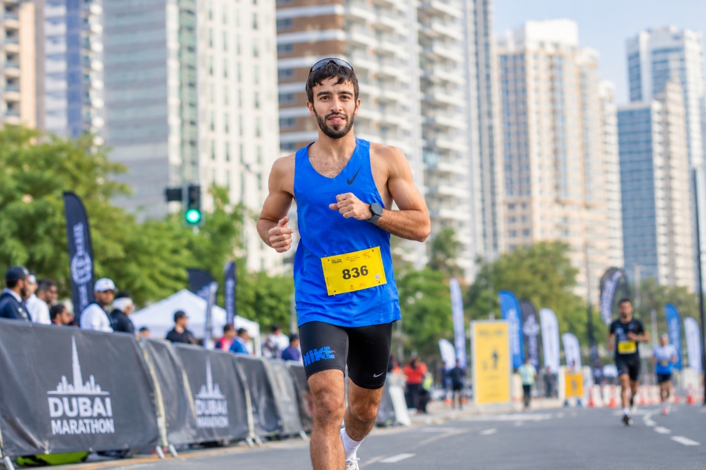 Marathon runner in blue jersey with bib 836 competing in road race